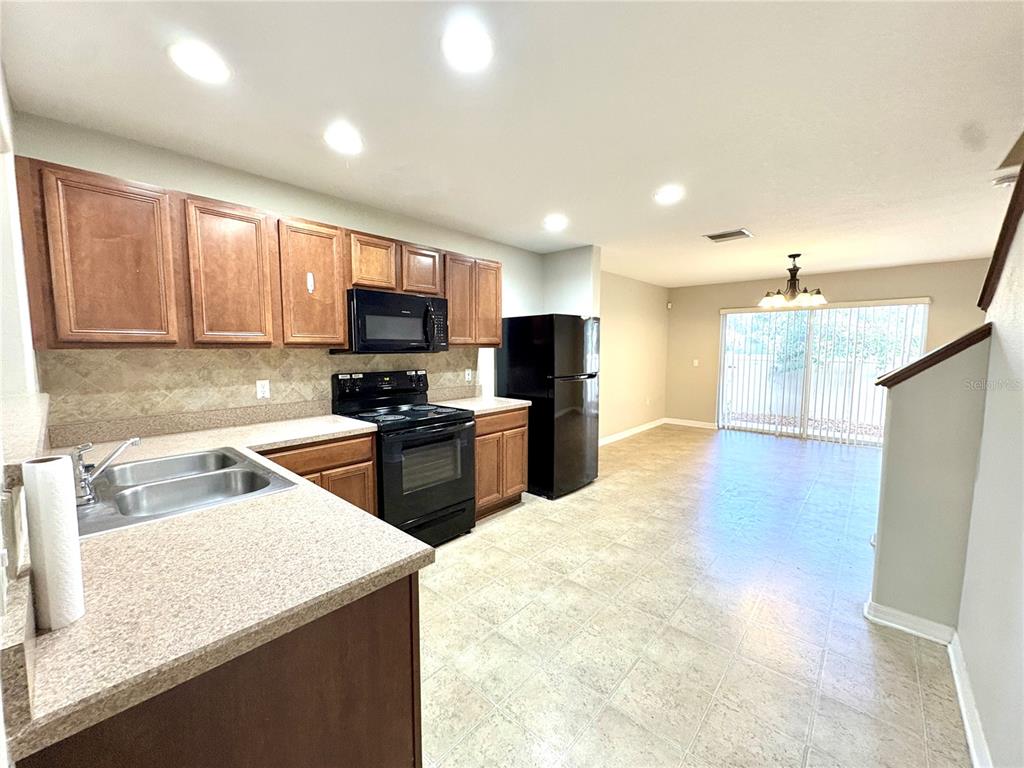 10812 Kensington Park Avenue Riverview, FL 33578 - Photo 6 of 20 a kitchen with stainless steel appliances granite countertop a sink refrigerator and microwave