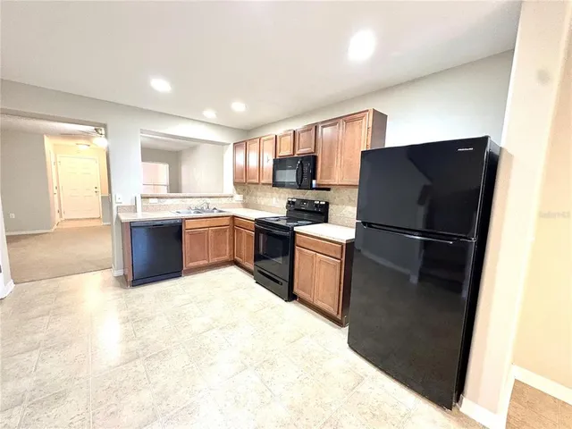 a kitchen with a refrigerator sink and wooden cabinets