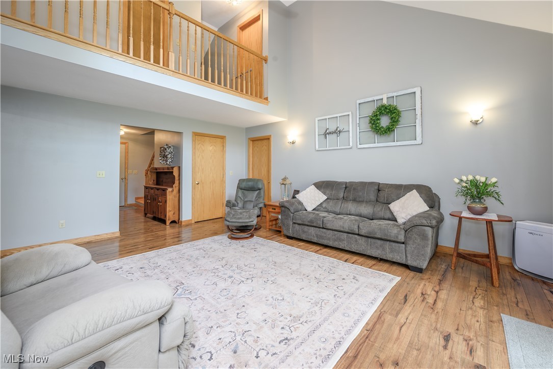 6640 Giddings Road Rootstown, OH 44272 - Photo 31 of 49 Living room featuring high vaulted ceiling and wood finished floors