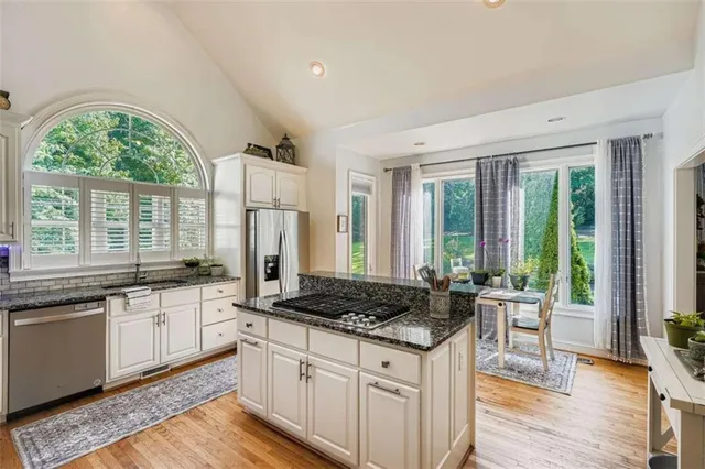 a kitchen with stainless steel appliances granite countertop a stove a sink and a refrigerator