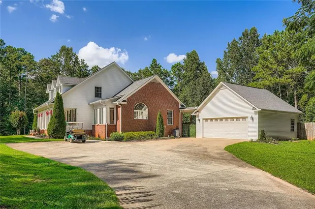 a front view of a house with a yard and trees