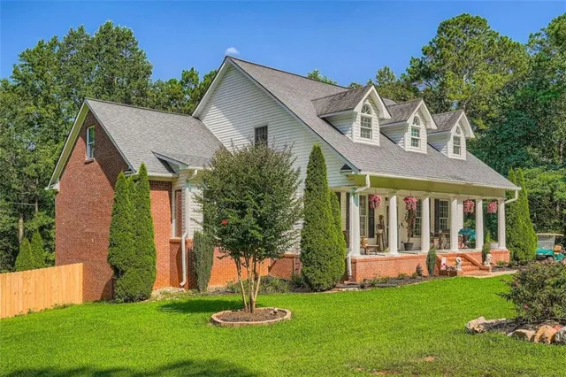 a front view of a house with a garden and yard