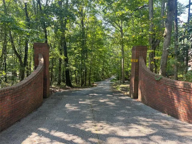 a front view of a house with a garden and trees