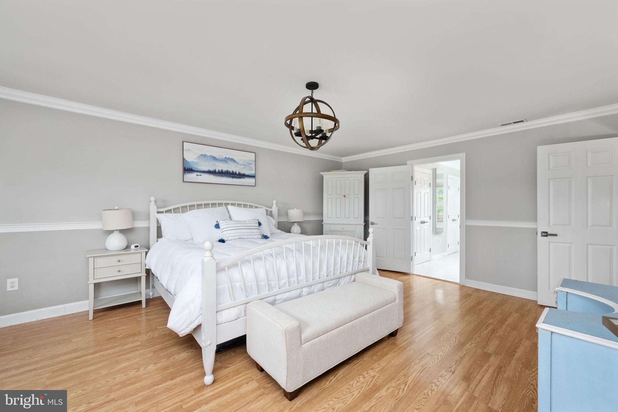 5191 Beach Ridge Lane Amissville, VA 20106 - Photo 23 of 91 a bedroom with a bed and a chandelier