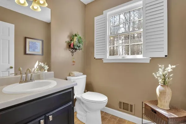 a bathroom with a toilet a sink and a window