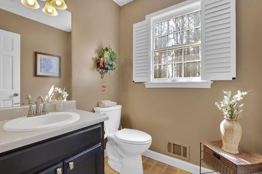 2385 Waterton Ridge Trail Grayson, GA 30017 - Photo 11 of 38 a bathroom with a toilet a sink and a window