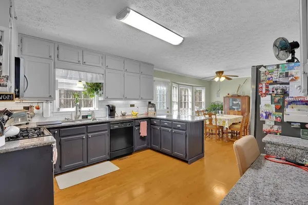 a kitchen with stainless steel appliances granite countertop a sink dishwasher stove and cabinets