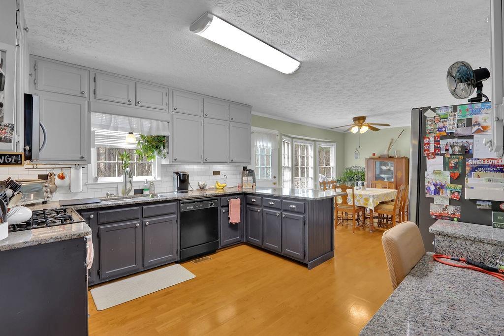 2385 Waterton Ridge Trail Grayson, GA 30017 - Photo 13 of 38 a kitchen with stainless steel appliances granite countertop a sink dishwasher stove and cabinets