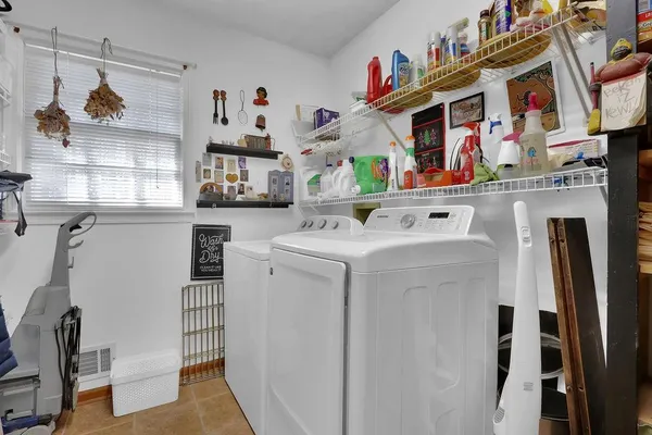 a utility room with dryer washer and a view of living room