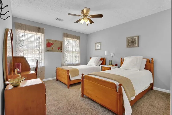 a bedroom with two beds and a chandelier