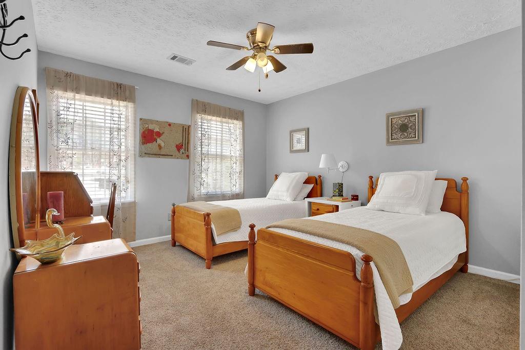 2385 Waterton Ridge Trail Grayson, GA 30017 - Photo 19 of 38 a bedroom with two beds and a chandelier