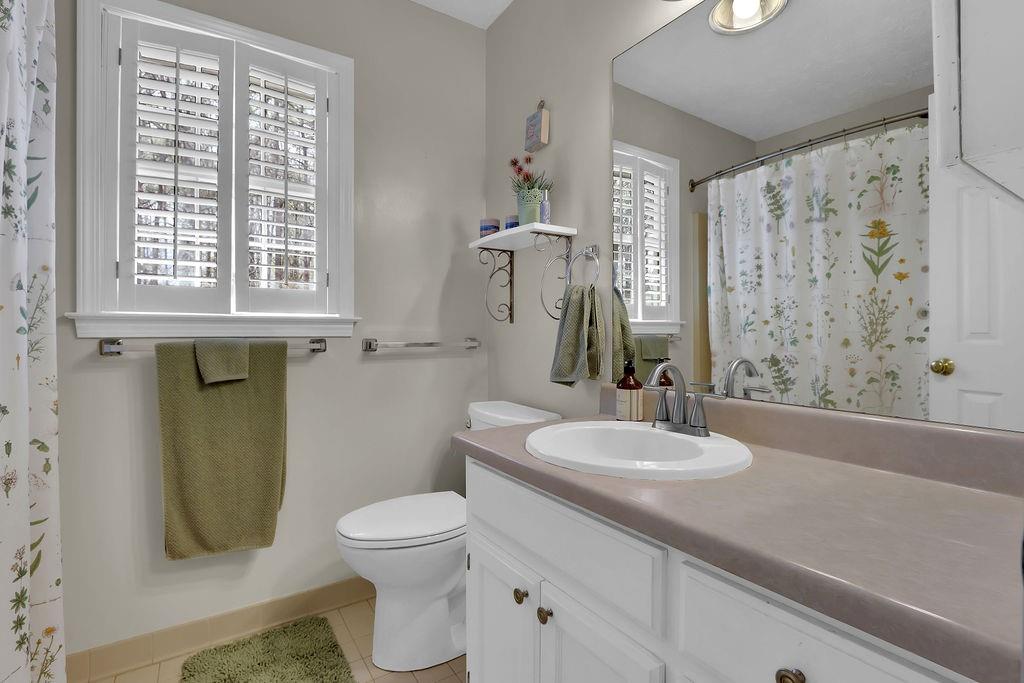 2385 Waterton Ridge Trail Grayson, GA 30017 - Photo 20 of 38 a bathroom with a granite countertop toilet a sink a mirror a window and a shower