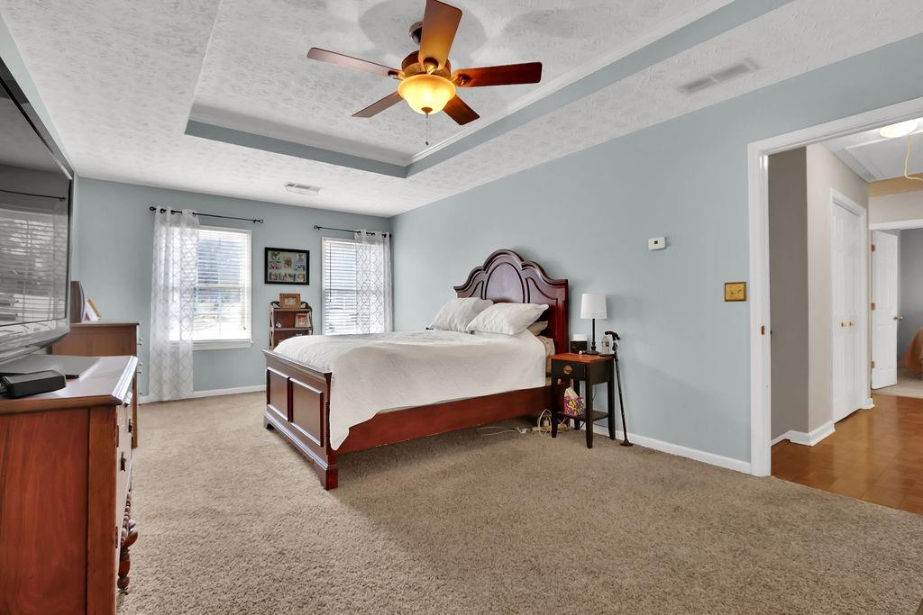 2385 Waterton Ridge Trail Grayson, GA 30017 - Photo 23 of 38 a bedroom with a bed and a chandelier