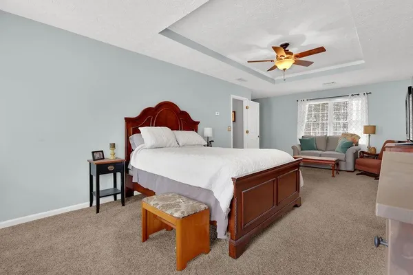 a spacious bedroom with a bed and a chandelier