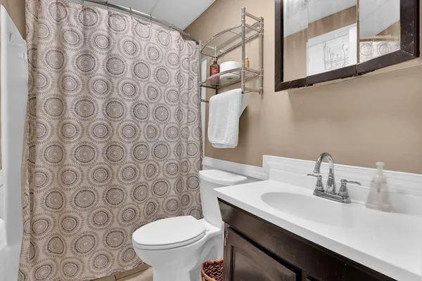 a bathroom with a sink a toilet and a mirror