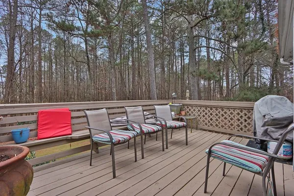 a patio of a house with wooden chairs and wooden fence