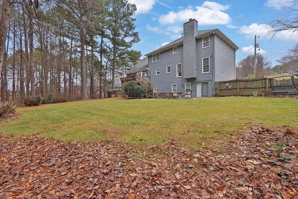 a view of a house with a yard and a large tree