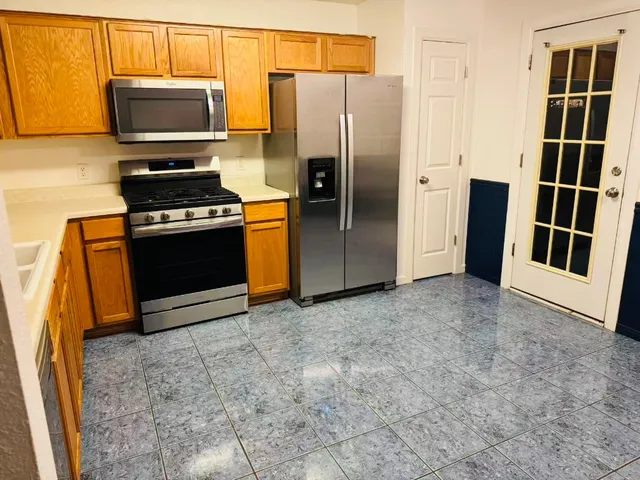 a kitchen with stainless steel appliances a refrigerator and a stove top oven