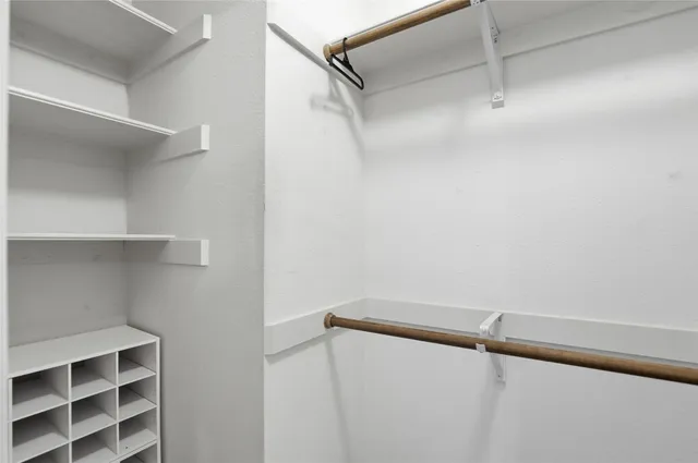 a view of walk in closet with empty racks