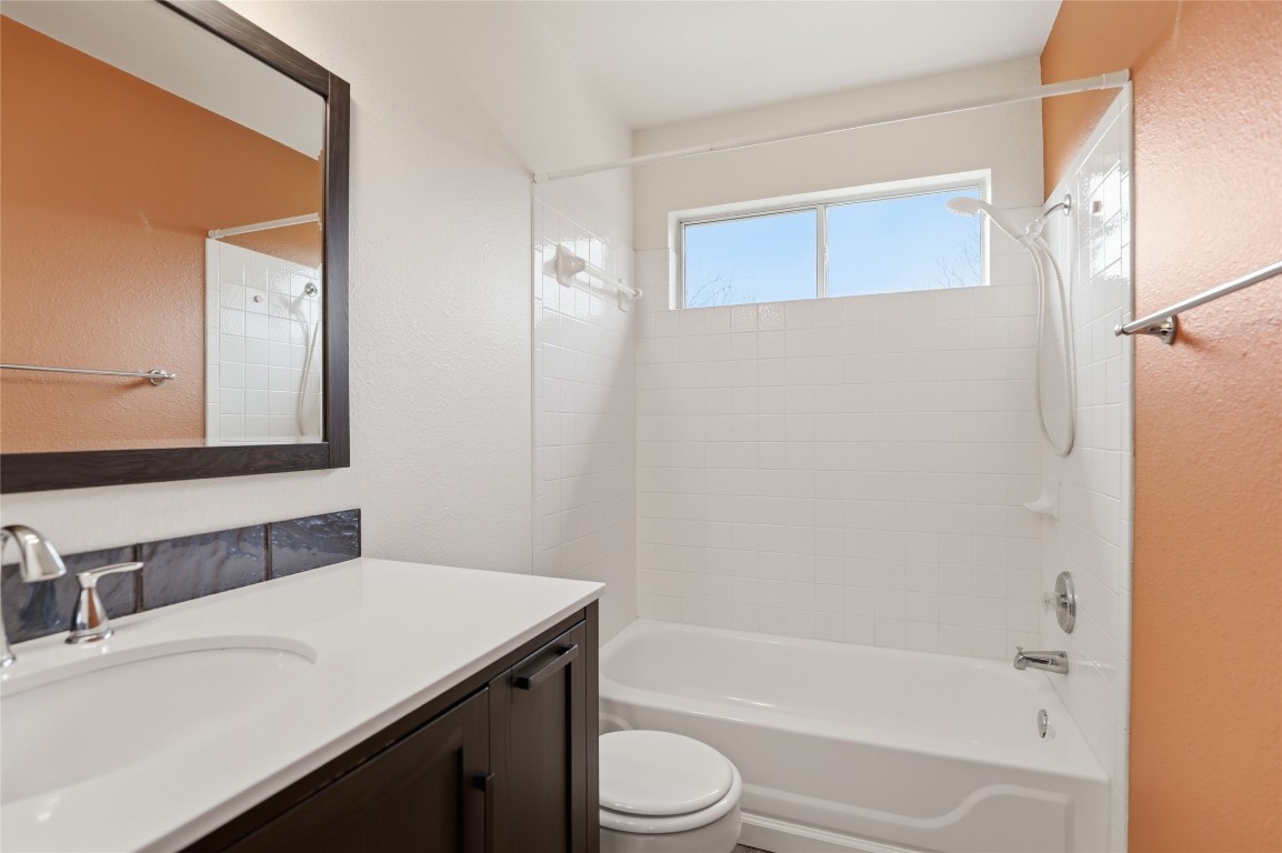3215 Port Anne Way Leander, TX 78641 - Photo 22 of 30 a bathroom with a granite countertop sink toilet and shower