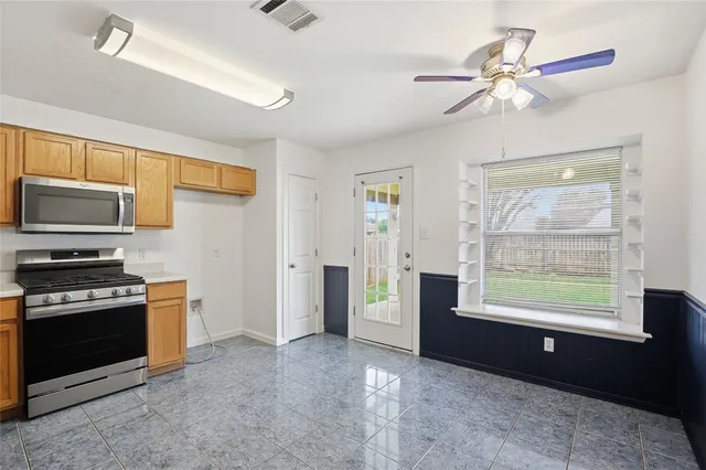a view of a kitchen with furniture a ceiling fan and window