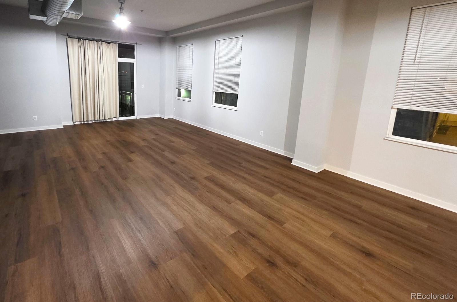 1521 Central Street, Unit 2D Denver, CO 80211 - Photo 13 of 35 a view of an empty room with wooden floor and a window