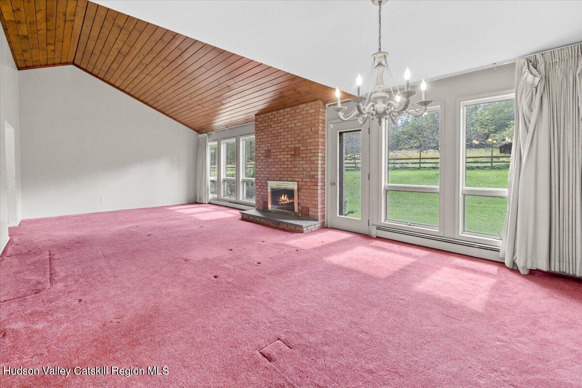 119 Mt Laurel Road Kerhonkson, NY 12446 - Photo 14 of 29 a view of a livingroom with a fireplace a ceiling fan and windows