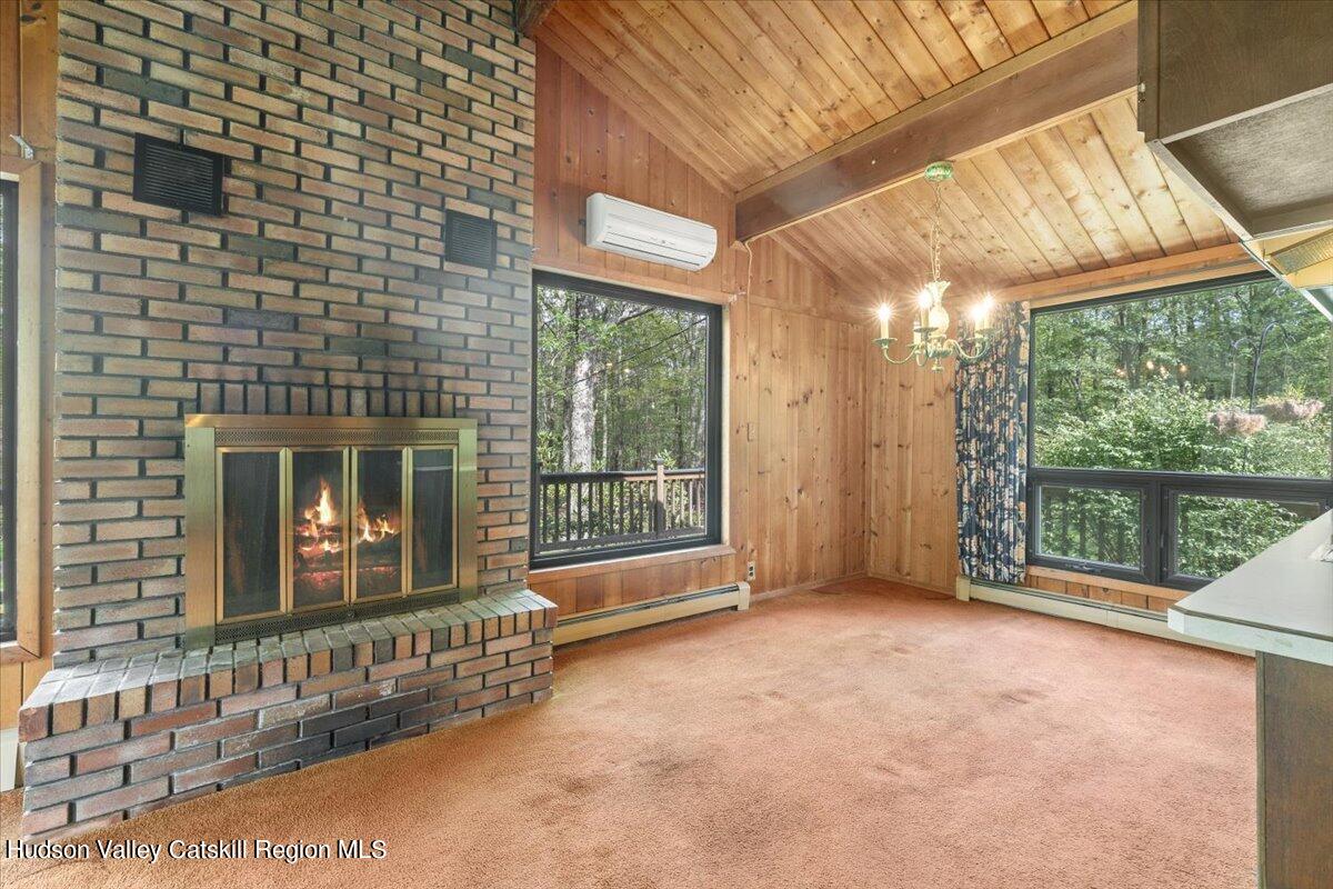 119 Mt Laurel Road Kerhonkson, NY 12446 - Photo 21 of 29 a view of an empty room with wooden floor and a fireplace