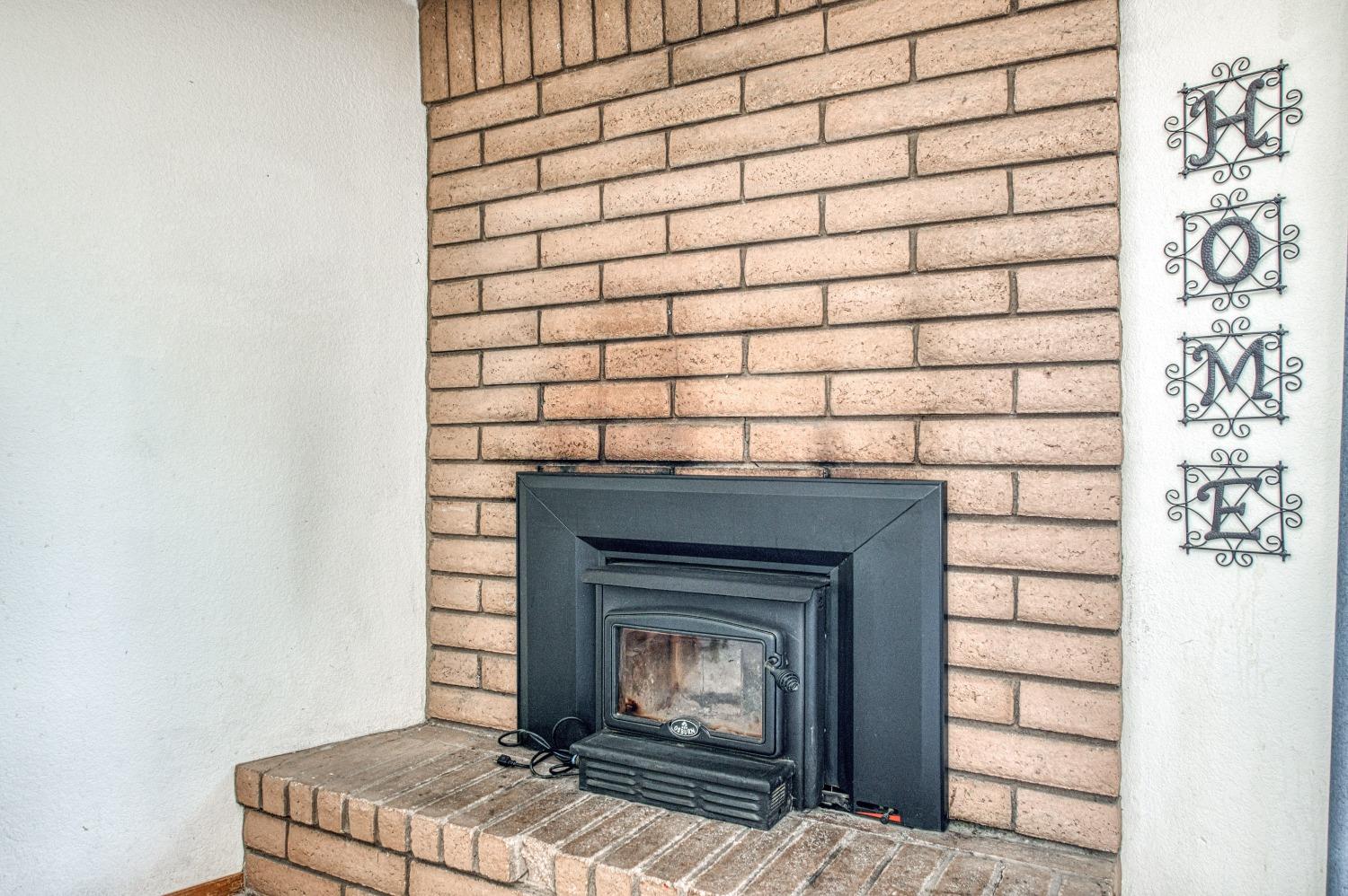 35516 John Albert Drive Madera, CA 93636 - Photo 16 of 60 a room with a fireplace and a rug