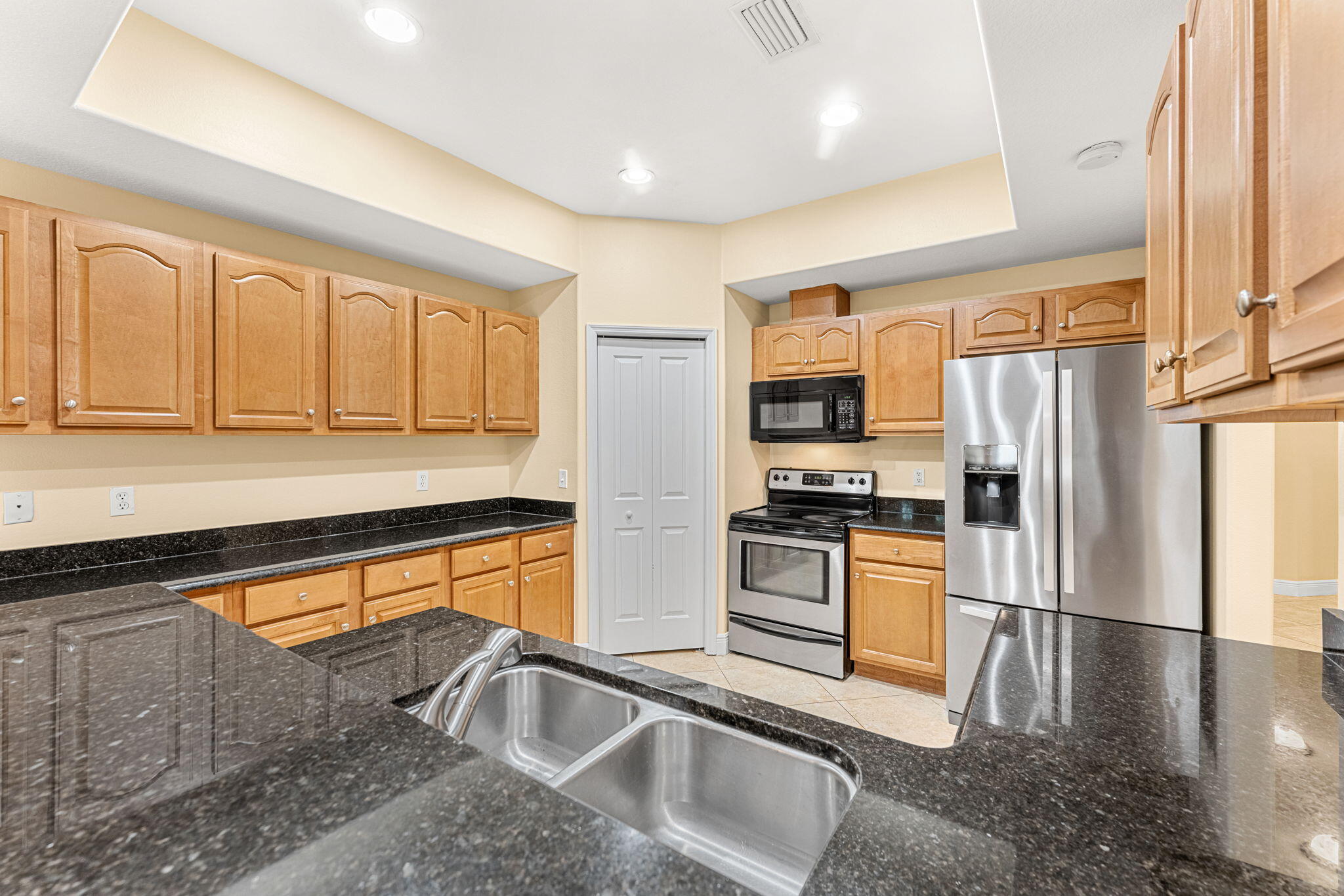 204 Holman Road, Unit 3 Cape Canaveral, FL 32920 - Photo 20 of 61 a kitchen with stainless steel appliances granite countertop a refrigerator a stove and a sink with wooden floor