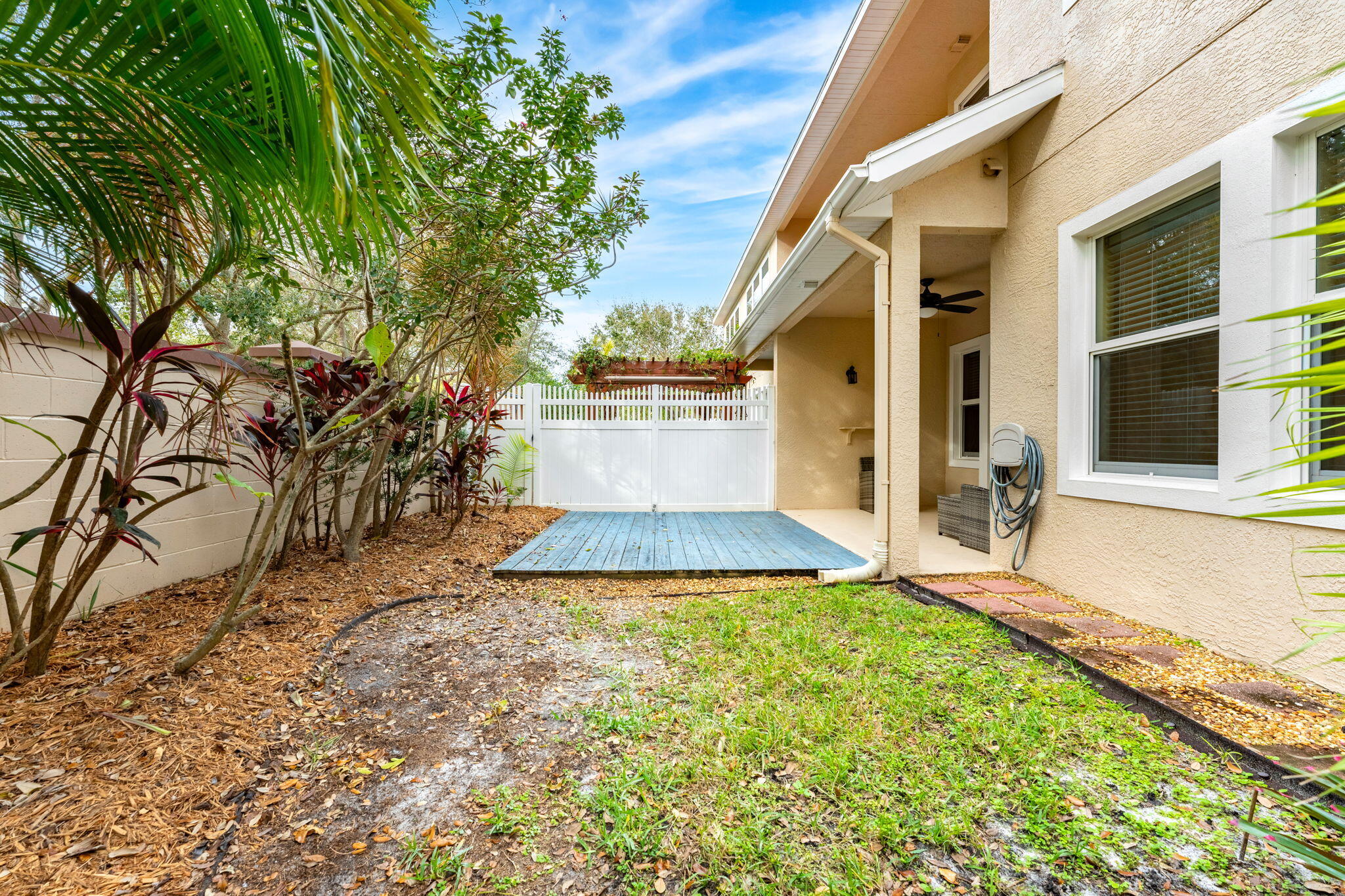 204 Holman Road, Unit 3 Cape Canaveral, FL 32920 - Photo 30 of 61 a view of a white house with a yard and potted plants