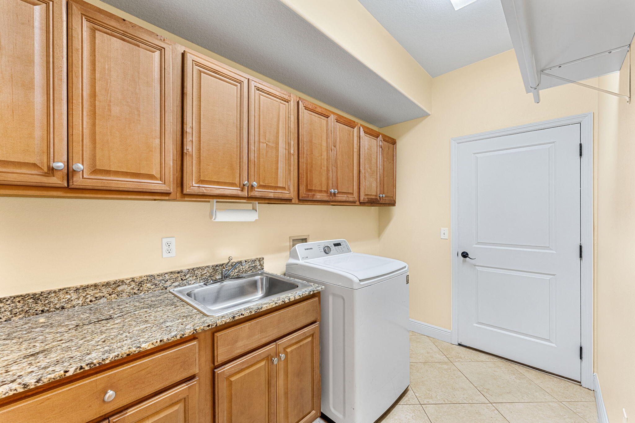 204 Holman Road, Unit 3 Cape Canaveral, FL 32920 - Photo 49 of 61 a utility room with granite countertop cabinets washer and dryer