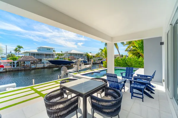 a living room with furniture kitchen view and large windows