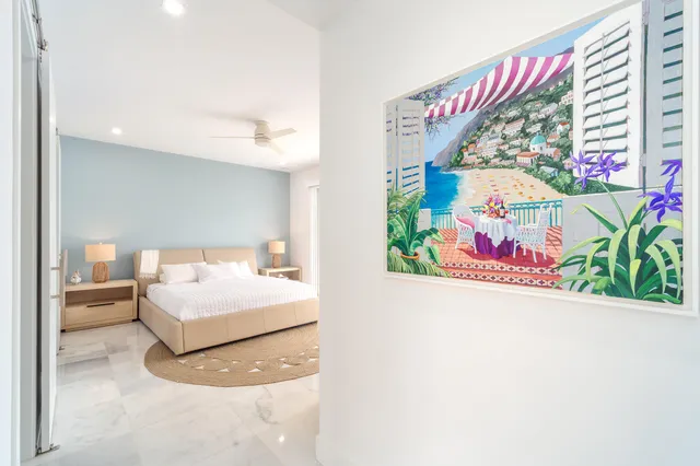 a bedroom with a bed and a painting on the wall