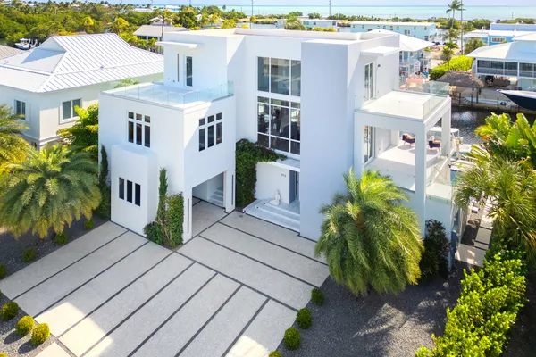 a view of a house with pool and chairs