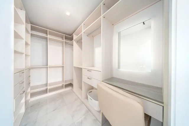 a bedroom with furniture and a large window