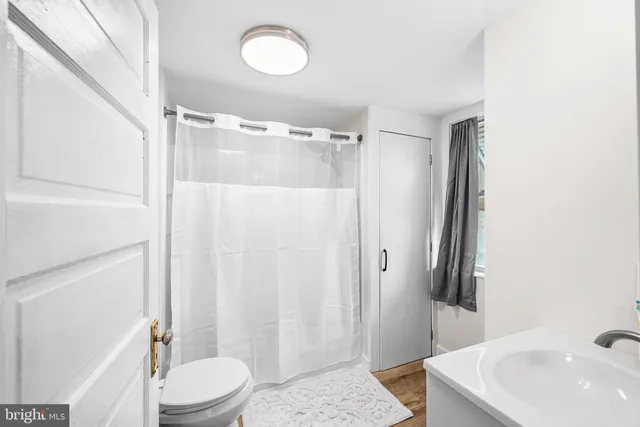 a bathroom with a sink a toilet a mirror and shower