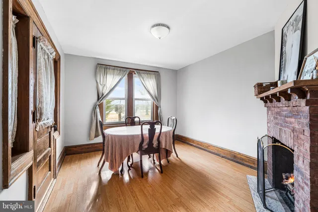 a dining room with furniture a fireplace and wooden floor
