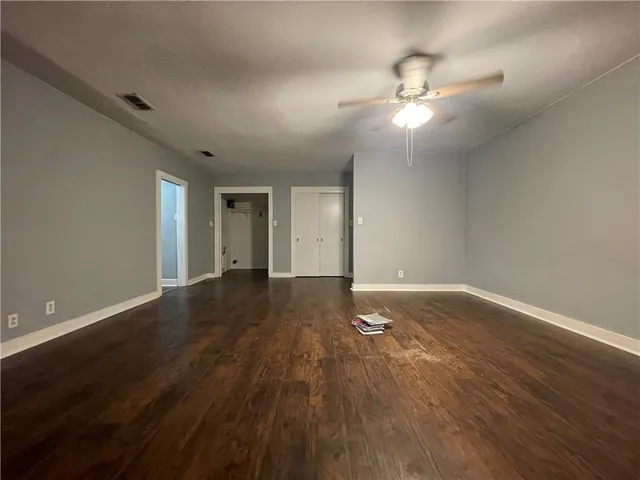 a view of an empty room with wooden floor