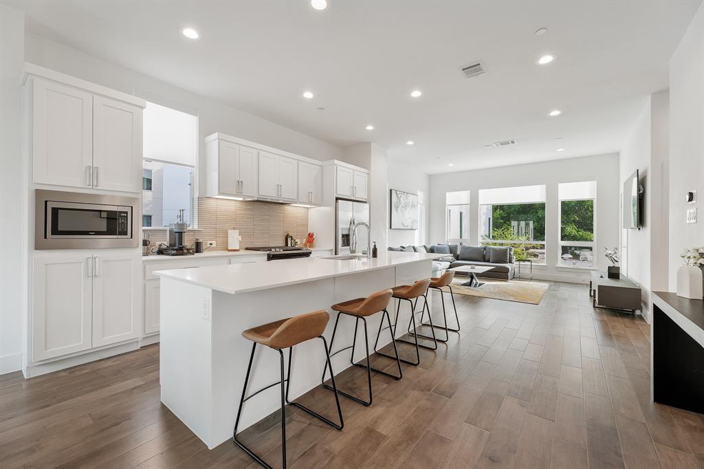 1771 Mccoy Street, Unit 401 Dallas, TX 75204 - Photo 30 of 30 Kitchen with tasteful backsplash, white cabinetry, a kitchen island with sink, open floor plan, and recessed lighting