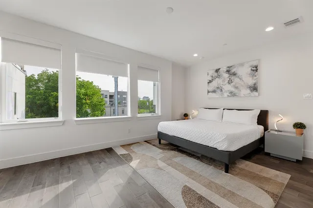 a bedroom with a bed and a painting on the wall