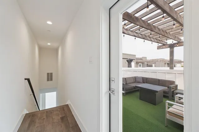 a view of a bedroom with wooden floor and white walls