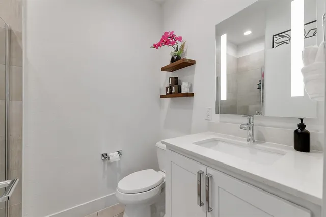 a bathroom with a sink vanity mirror and toilet