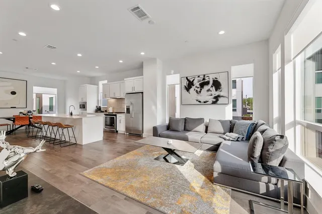 a living room with furniture and a dining table with kitchen view