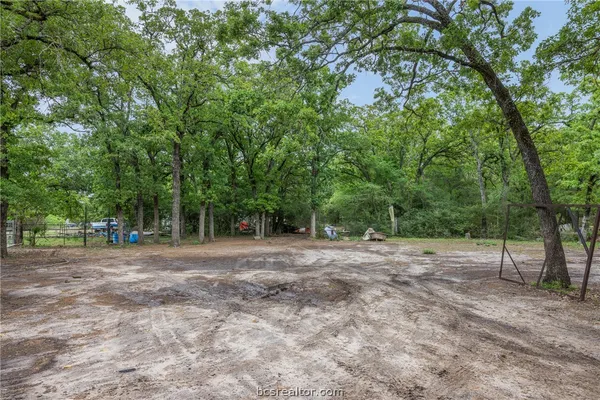 a view of a yard with large trees