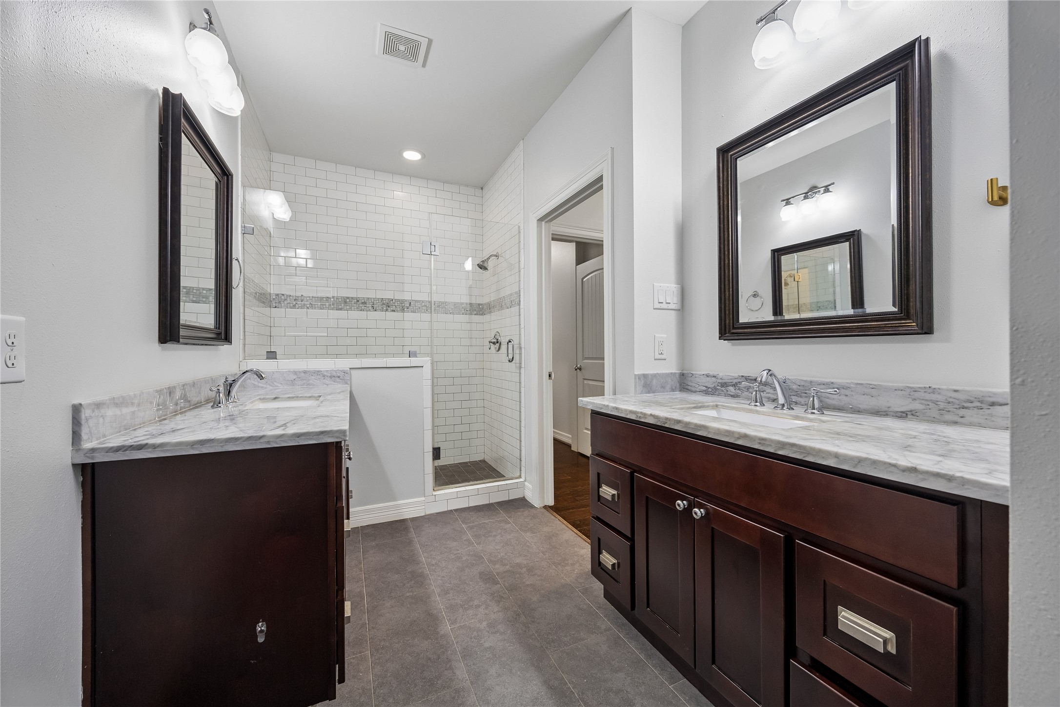 5121 Libbey Drive Houston, TX 77092 - Photo 9 of 24 The primary bath is designed for relaxation, complete with a deep soaking tub and a separate shower outfitted with a built-in bench. Dual vanities offer plenty of personal space, creating a refined and functional retreat.