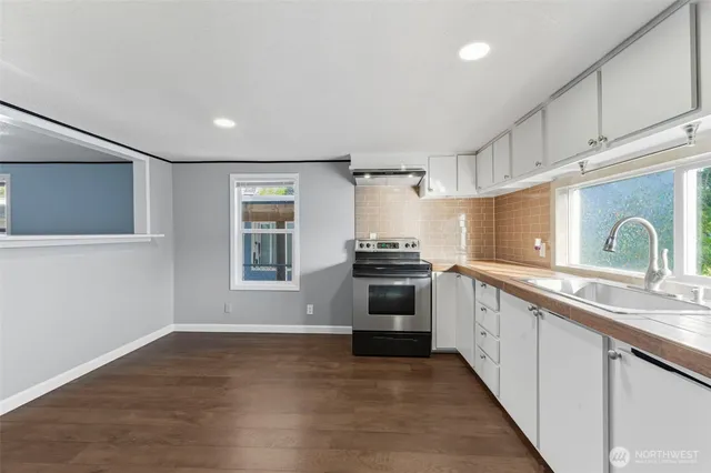 a kitchen with granite countertop white cabinets and appliances