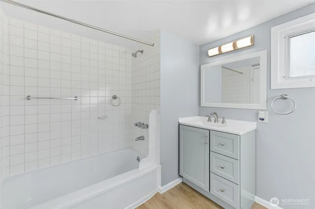 a bathroom with a sink mirror and a bathtub