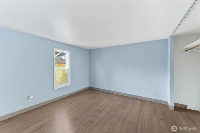 an empty room with a window and wooden floor
