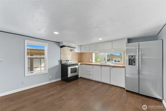 a kitchen with a refrigerator and a stove top oven